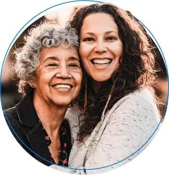 Two females embracing while smiling.
