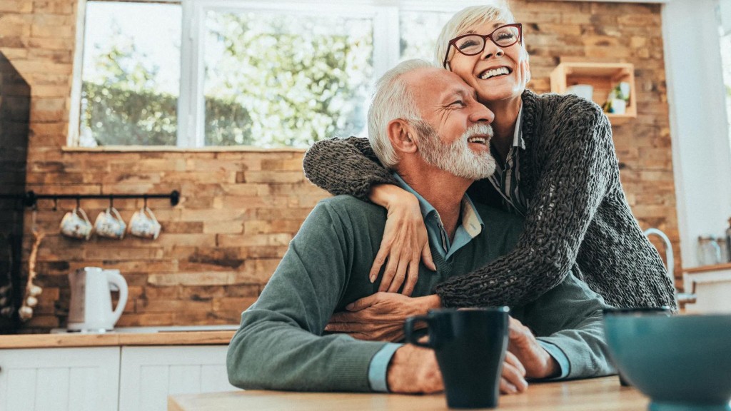 Senior female with glasses embracing a male senior, both are smiling