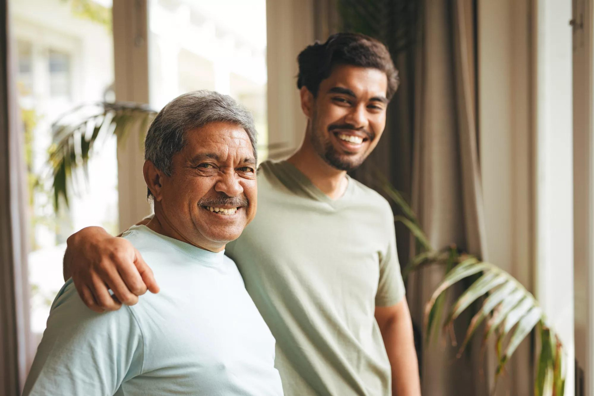 Two men, one older and one younger, smiling happily at the camera.